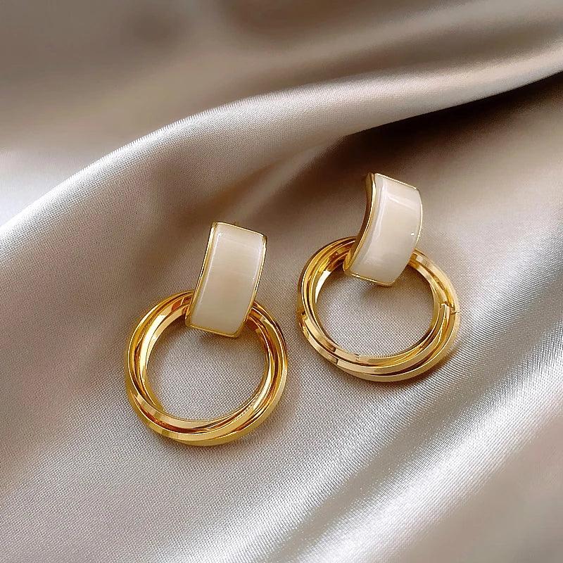 WOLZI Opaline Halo Drop Earrings featuring cream enamel and gold-toned hoops on satin fabric