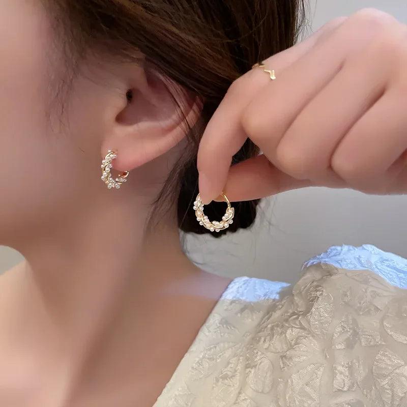 WOLZI Lumi Pearl Circle Stud Earrings in gold with shimmering pearl accents.