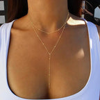 WOLZI Solara Tassel Layered Necklace in gold on a woman wearing a white top