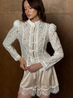 Model wearing WOLZI Fontaine white lace blouse with puff sleeves and satin shorts.