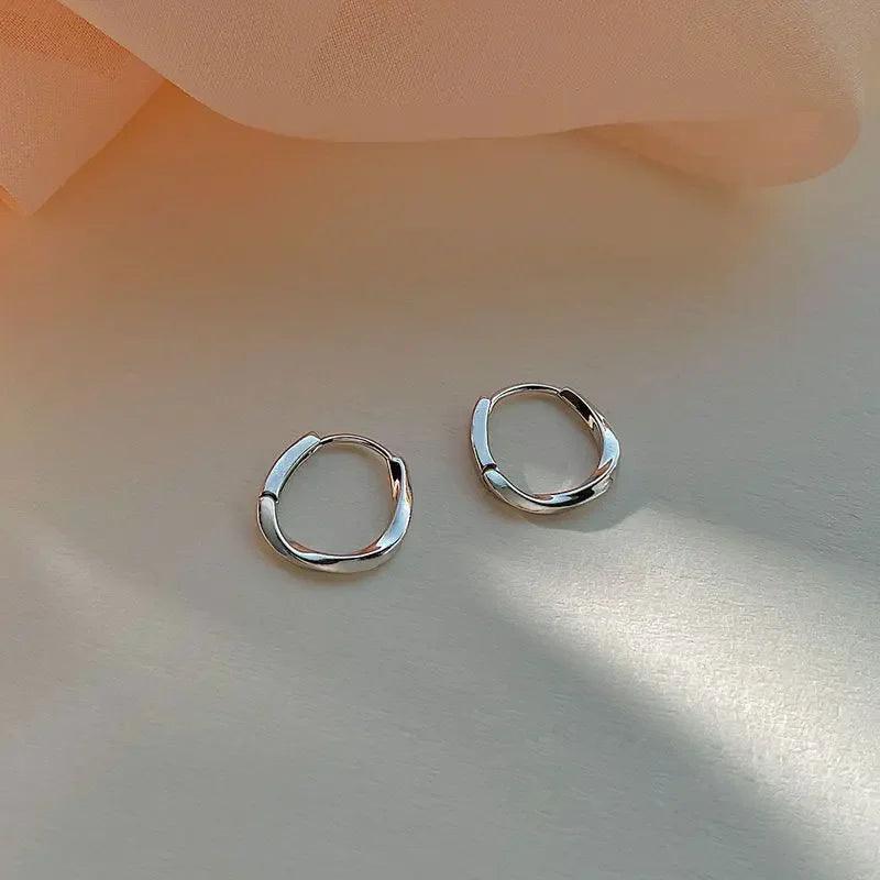 Lumi Pearl Circle Stud Earrings by WOLZI on a soft peach background