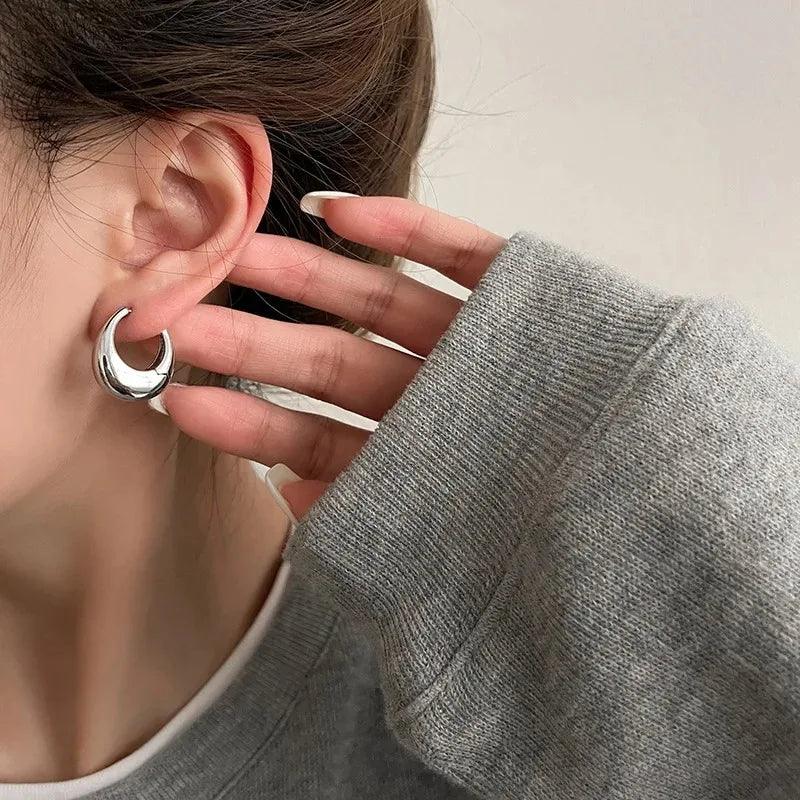 Aurelle Sculpted Oval Earrings by WOLZI worn by a woman