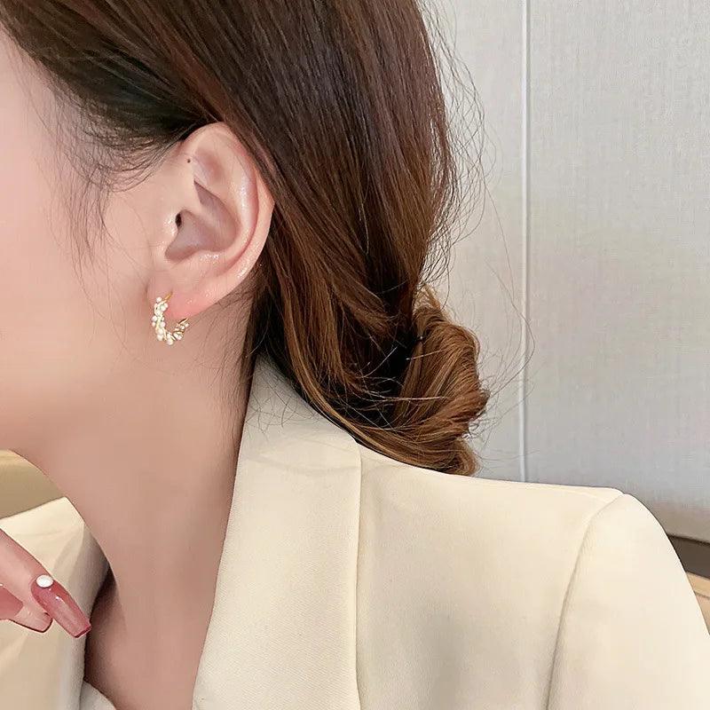 WOLZI Lumi Pearl Circle Stud Earrings worn by a woman in a white blazer.