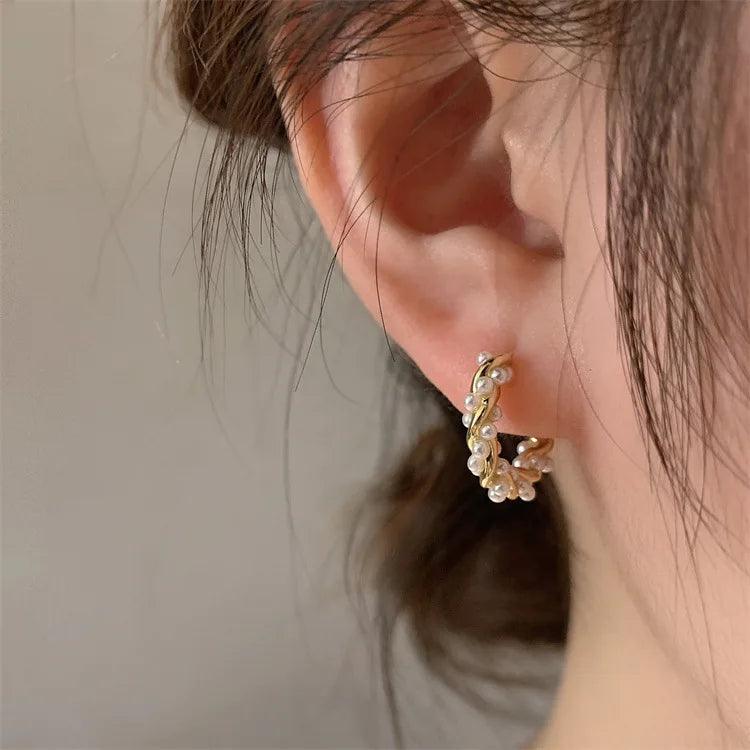 Lumi Pearl Circle Stud Earrings by WOLZI worn on a woman's ear