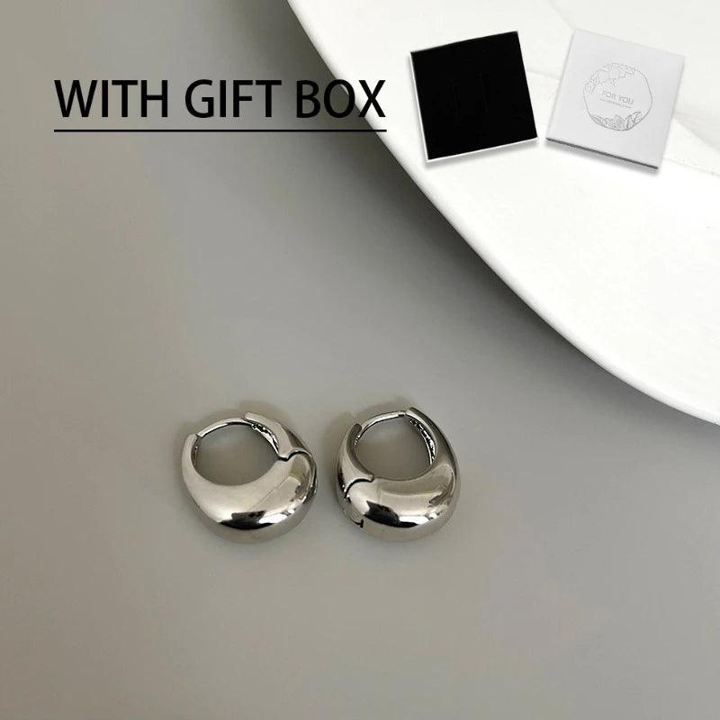 WOLZI Aurelle Sculpted Oval Earrings in silver with a gift box.