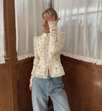 Woman wearing WOLZI Fontaine Lace Blouse in beige with long sleeves and denim jeans.