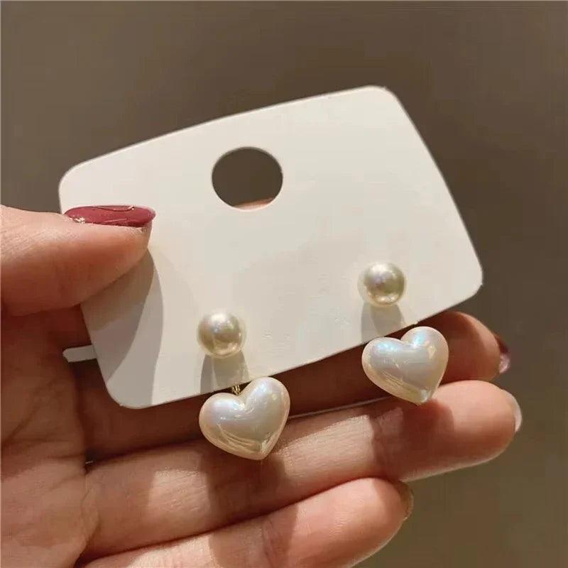 WOLZI Amelie Heart Pearl Earrings featuring white heart-shaped pearls on a white display card.