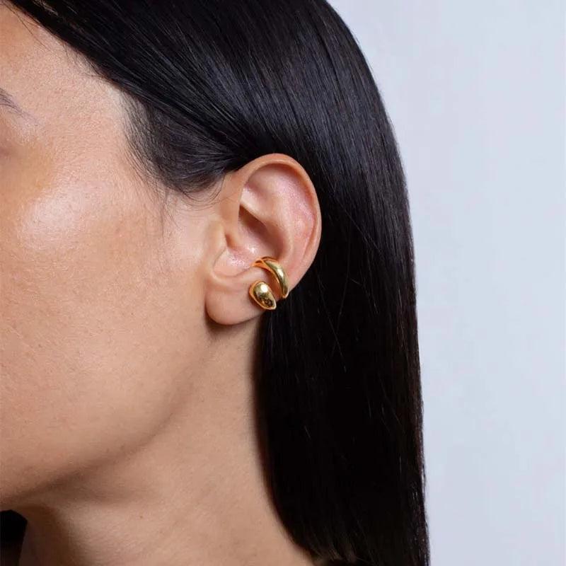 Aria Sculpted Gold Ear Cuff by WOLZI worn on a woman's ear