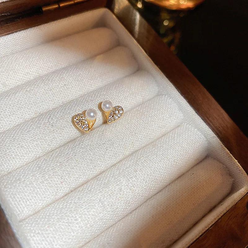 WOLZI Amelie Heart Pearl Earrings with gold heart settings and sparkling stones in a jewelry box