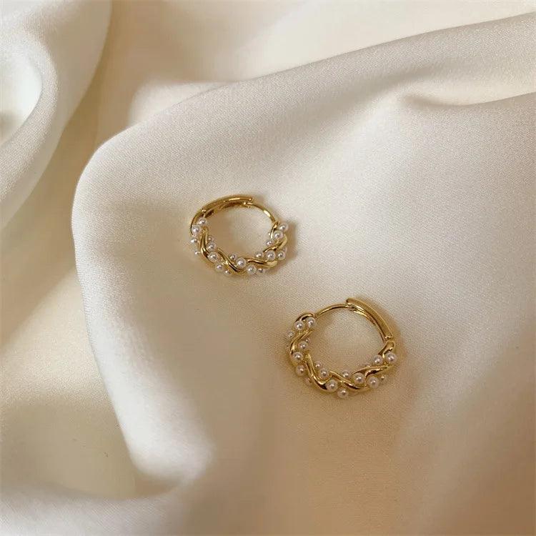 Lumi Pearl Circle Stud Earrings by WOLZI set on white silk fabric