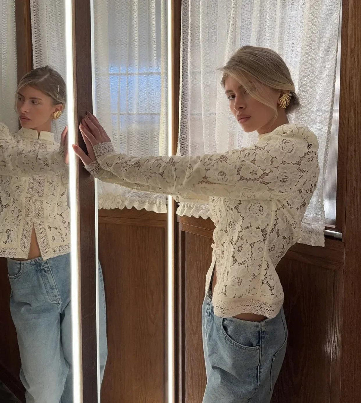 Woman wearing a WOLZI Fontaine Lace Blouse in beige paired with light blue jeans.