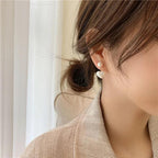 WOLZI Amelie Heart Pearl Earrings worn by a woman